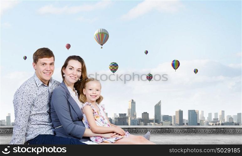 Young family. Happy family of three lying on green grass