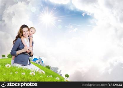 Young family. Happy mother with daughter sitting on green grass