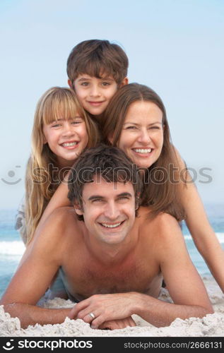 Young Family Having Fun On Beach Holiday