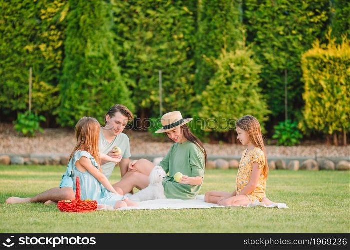 Young family having fun on the picnic in a park. Happy family on a picnic in the park on a sunny day