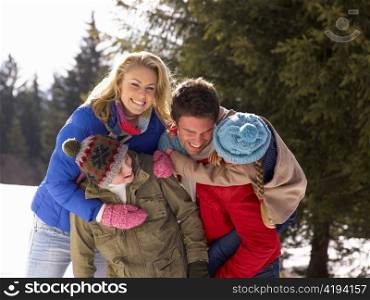Young Family In Alpine Snow Scene