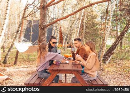 Young family in autumn day on picnic. Family Camping. Happy family on a picnic in the park at autumn