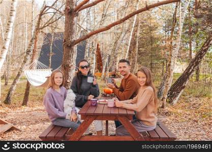 Young family in autumn on picnic. Family Camping. Happy family on a picnic in the park at autumn
