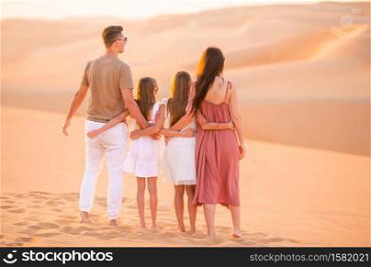 Young family in big sand desert. People among dunes in Rub al-Khali desert in United Arab Emirates