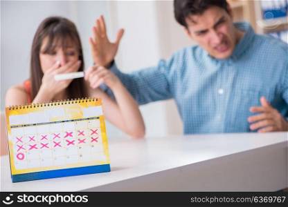 Young family in pregnancy planning concept with ovulation calendar. Young family in pregnancy planning concept with ovulation calend