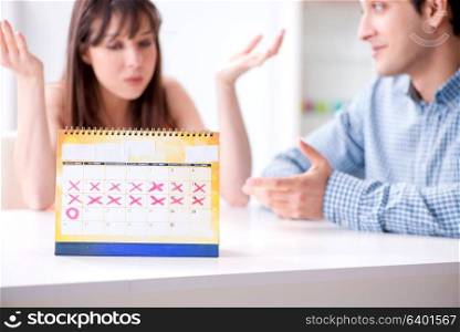 Young family in pregnancy planning concept with ovulation calendar. Young family in pregnancy planning concept with ovulation calend