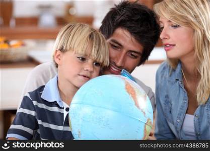 Young family looking at a globe