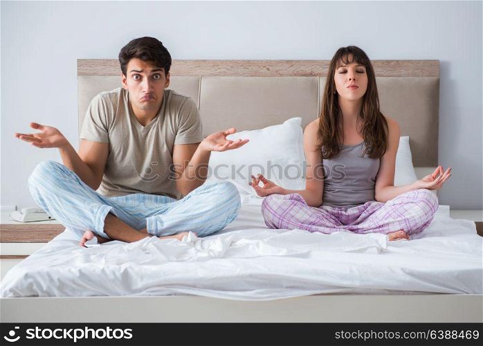 Young family meditating in the bed bedroom
