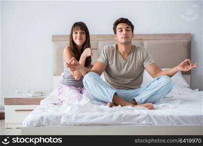 Young family meditating in the bed bedroom