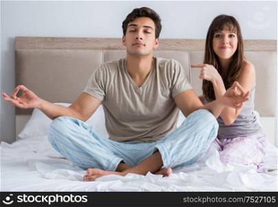 Young family meditating in the bed bedroom. The young family meditating in the bed bedroom