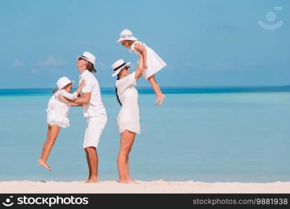 Young family of four on beach vacation. Family of four on beach vacation have fun