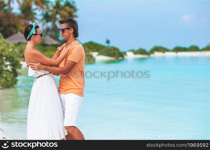 Young family of two on white beach. Young couple on white beach during summer vacation.