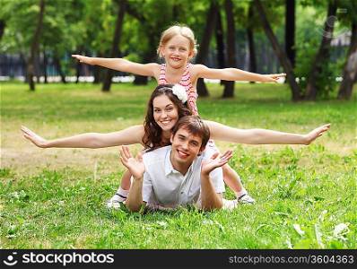 Young Family Outdoors on the grass in Park in summer