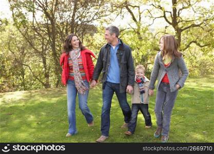 Young Family Outdoors Walking Through Park