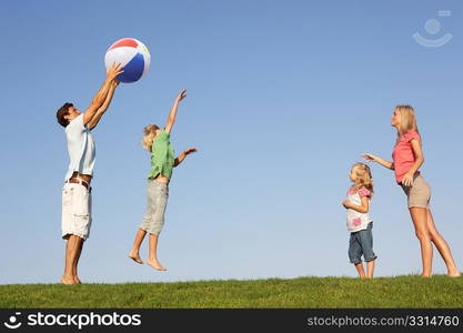 Young family, parents with children, playing in a field