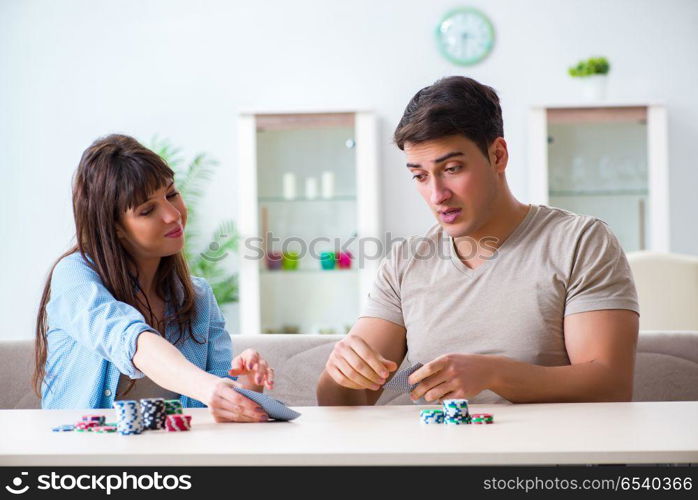 Young family playing cards at home