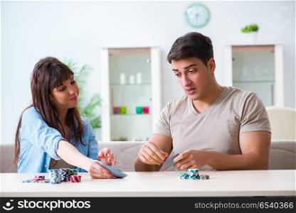 Young family playing cards at home