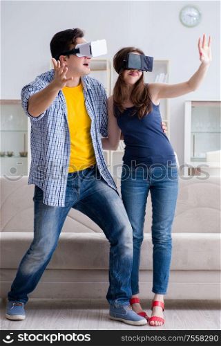 Young family playing games with virtual reality glasses. The young family playing games with virtual reality glasses