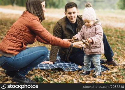 young family playing with leaves autumn forest