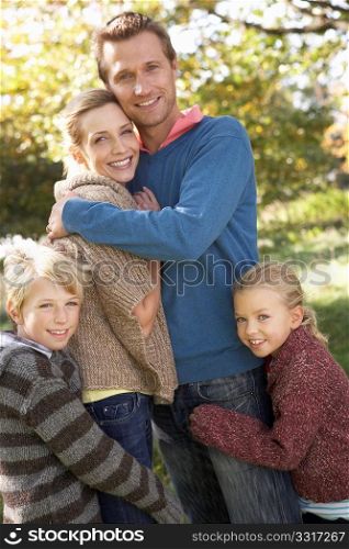 Young family pose in park
