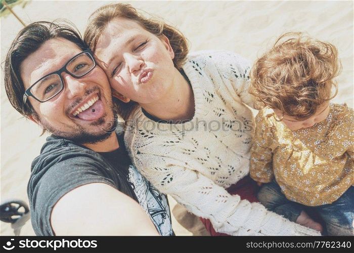 Young family posing together for a selfie in their holidays