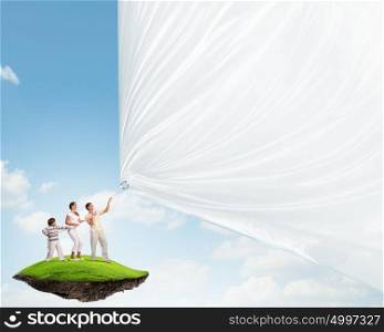 Young family pulling banner. Father and son pulling blank banner. Place for text