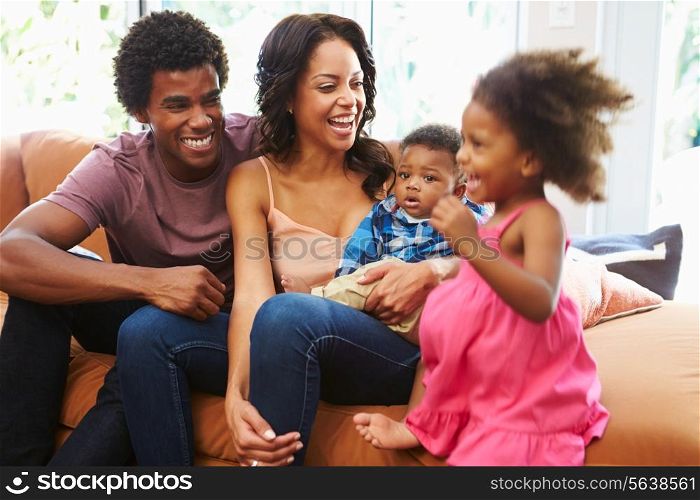 Young Family Relaxing On Sofa Together