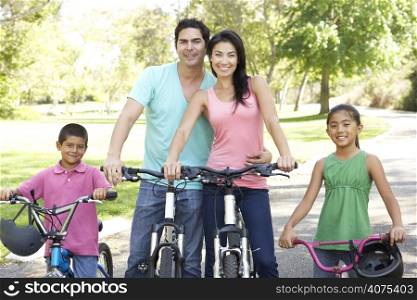 Young Family Riding Bikes In Park