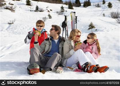 Young Family Sharing A Picnic On Ski Vacation