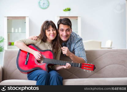 Young family singing and playing music at home