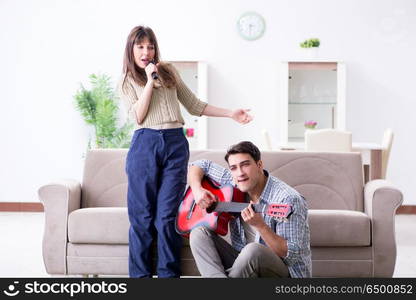 Young family singing and playing music at home