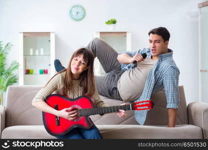 Young family singing and playing music at home