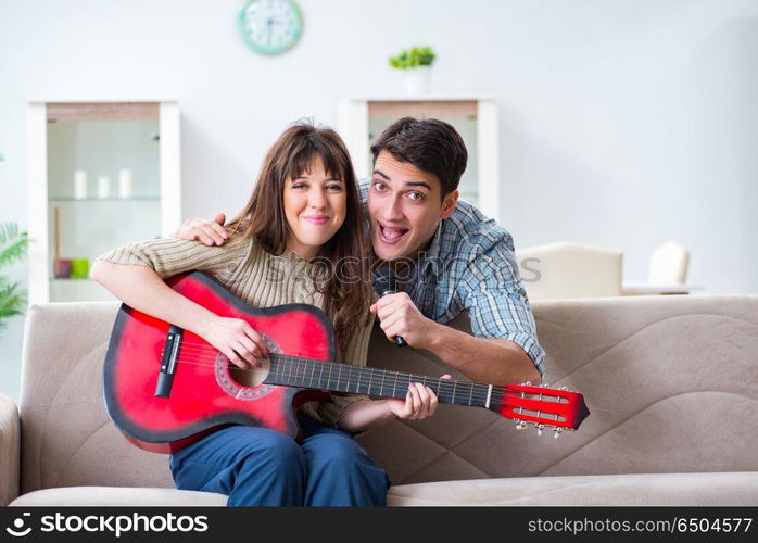 Young family singing and playing music at home