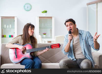 Young family singing and playing music at home