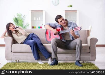 Young family singing and playing music at home