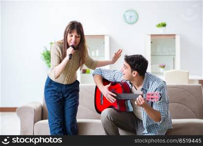 Young family singing and playing music at home