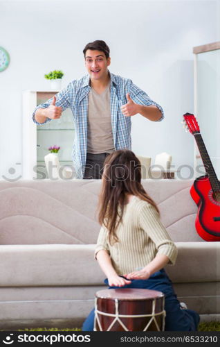 Young family singing and playing music at home