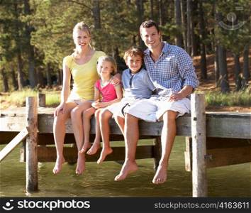Young family sitting by lake