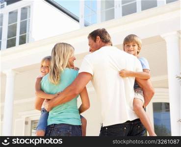 Young Family Standing Outside Dream Home
