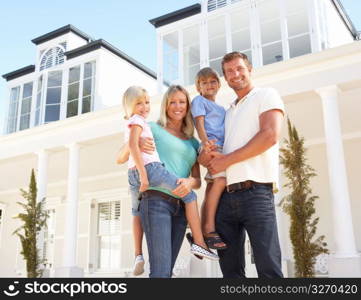 Young Family Standing Outside Dream Home