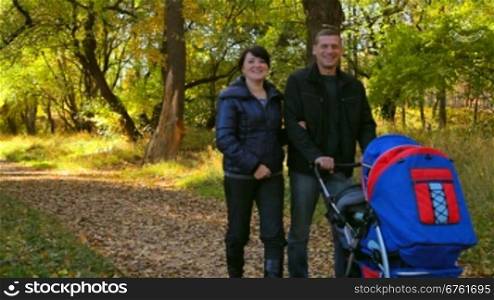 young family walks in the park with a stroller