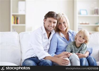 Young family with a child on the couch in the apartment