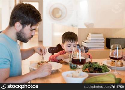 Young family with a little child sitting together for lunch
