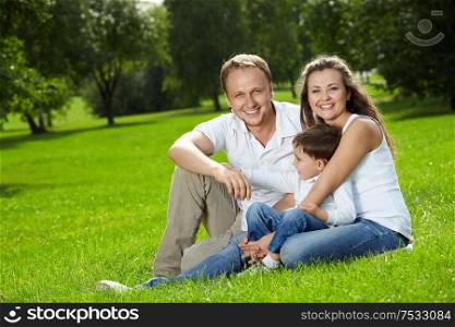 Young family with son have a rest in a summer garden