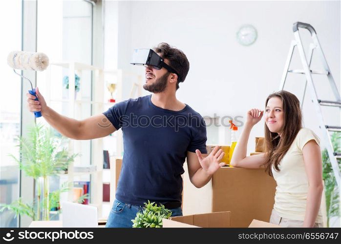 Young family with virtual glasses unpacking at new house with bo. Young family with virtual glasses unpacking at new house with boxes