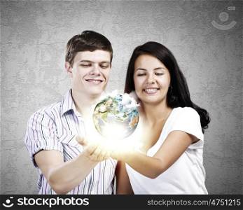 Young family. Young happy couple holding earth planet in palms. Elements of this image are furnished by NASA