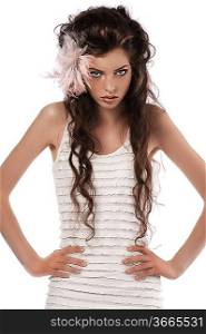 young fashion brunette with long curly hair and feather accessory in hair wearing white dress