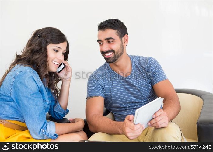 Young fashion couple using smartphone and tablet