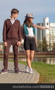 Young fashion elegant stylish couple in love posing in a European city park. Hipster cute girl with handsome man having fun outdoor.