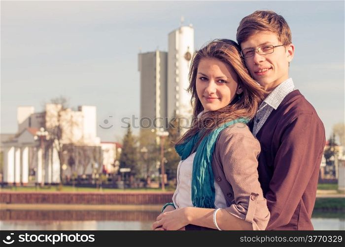 Young fashion elegant stylish couple posing in a European city park. Hipster cute girl with handsome man having fun outdoor.